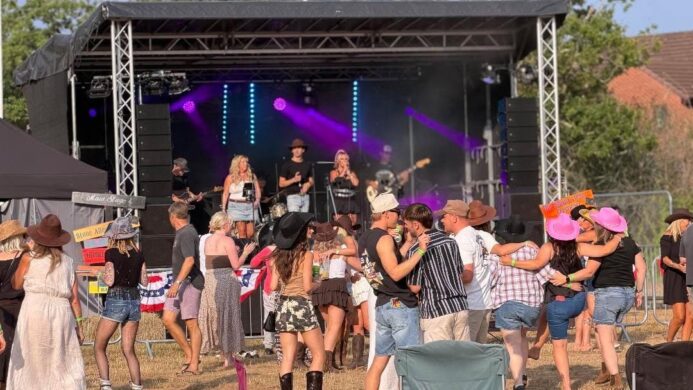 The Wild Ones Country Band performing live on a festival stage to a dancing crowd at a UK country music event