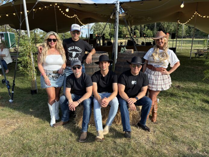 The Wild Ones Country Band posing at a western-style UK event with stage and hay bales in the background